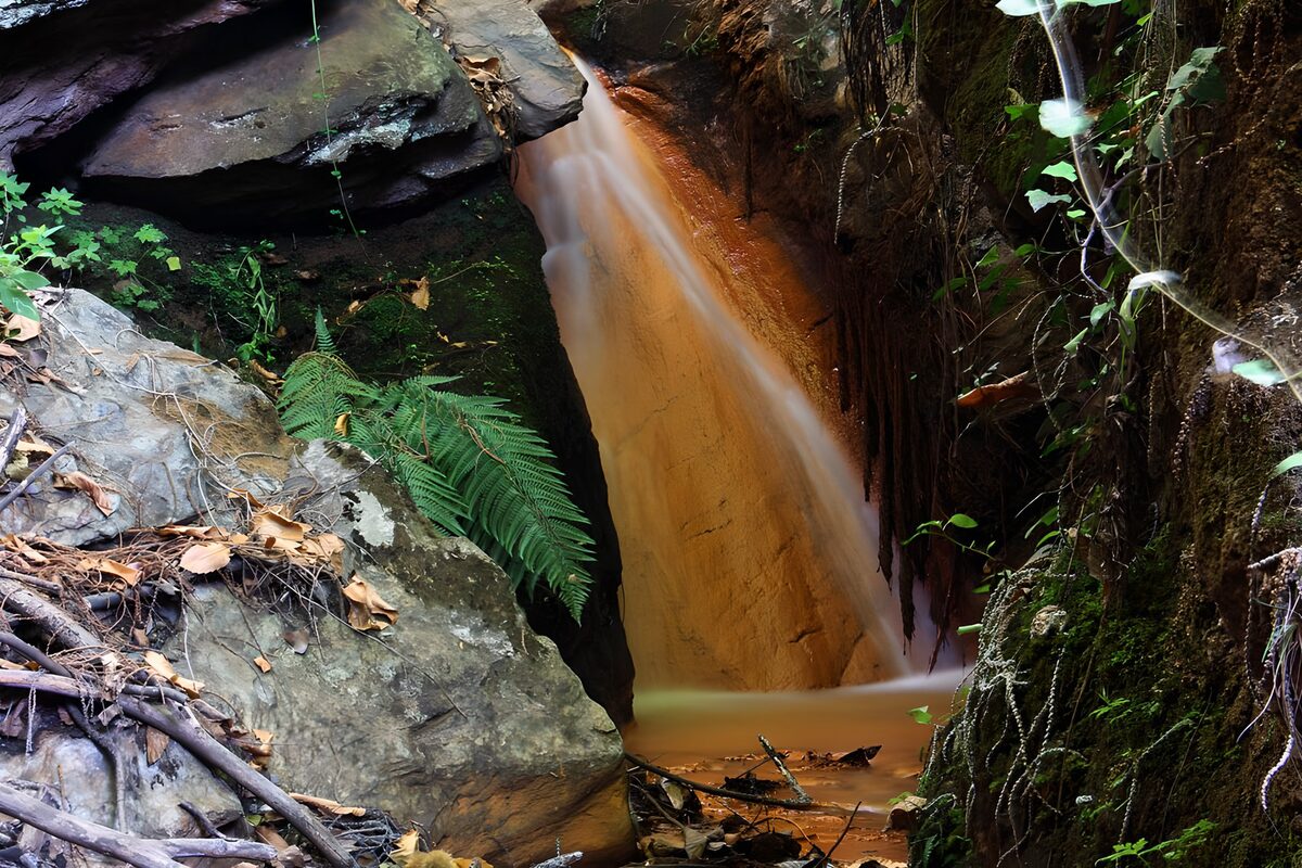 Waterval tussen rotsen en begroeiing
