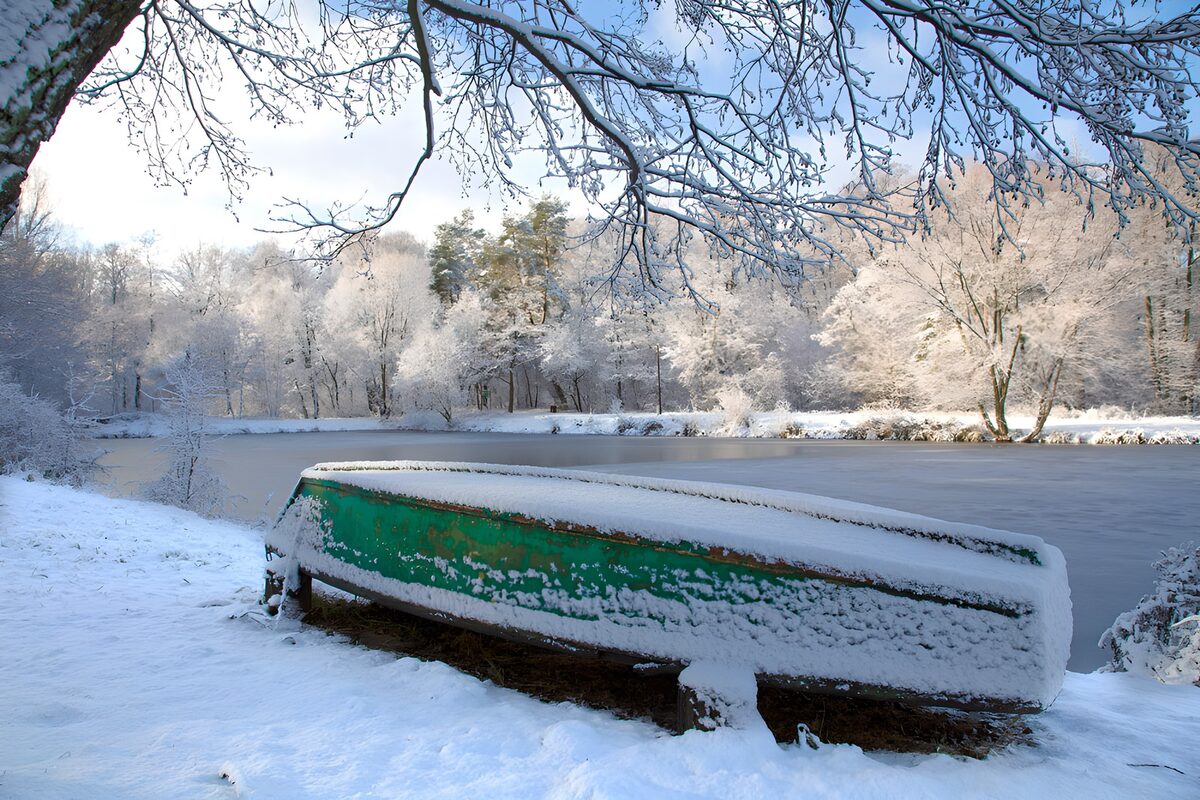 Sneeuwbedekte boot aan de oever