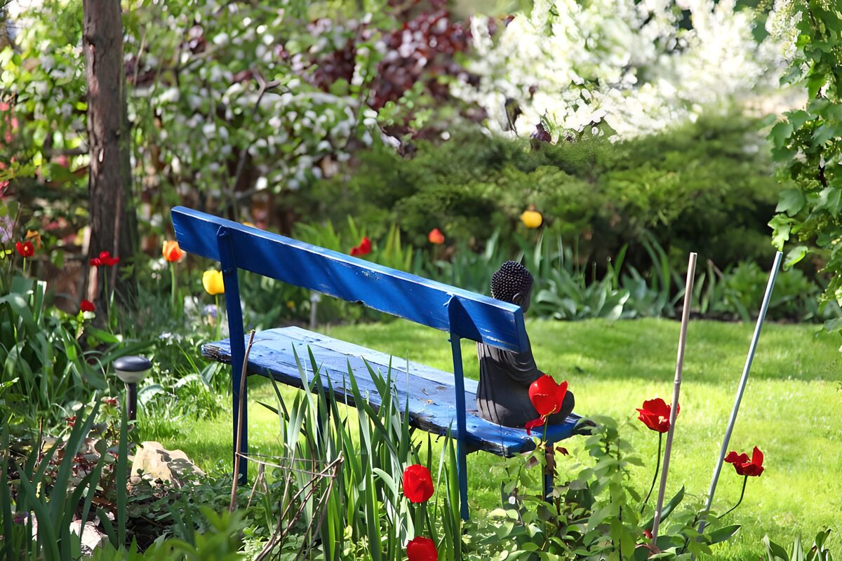 Rustige tuin met blauwe bank en bloemen