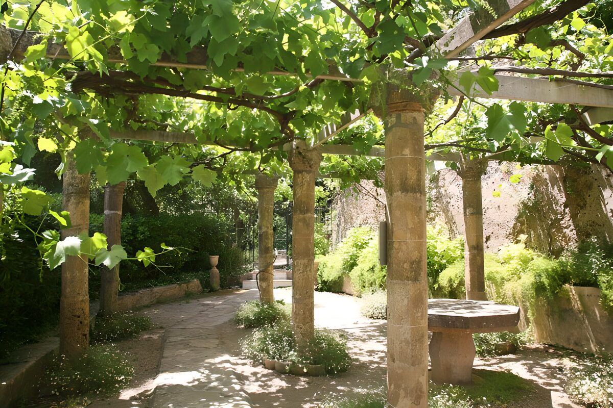 Lommerrijke tuin met zuilen en paden