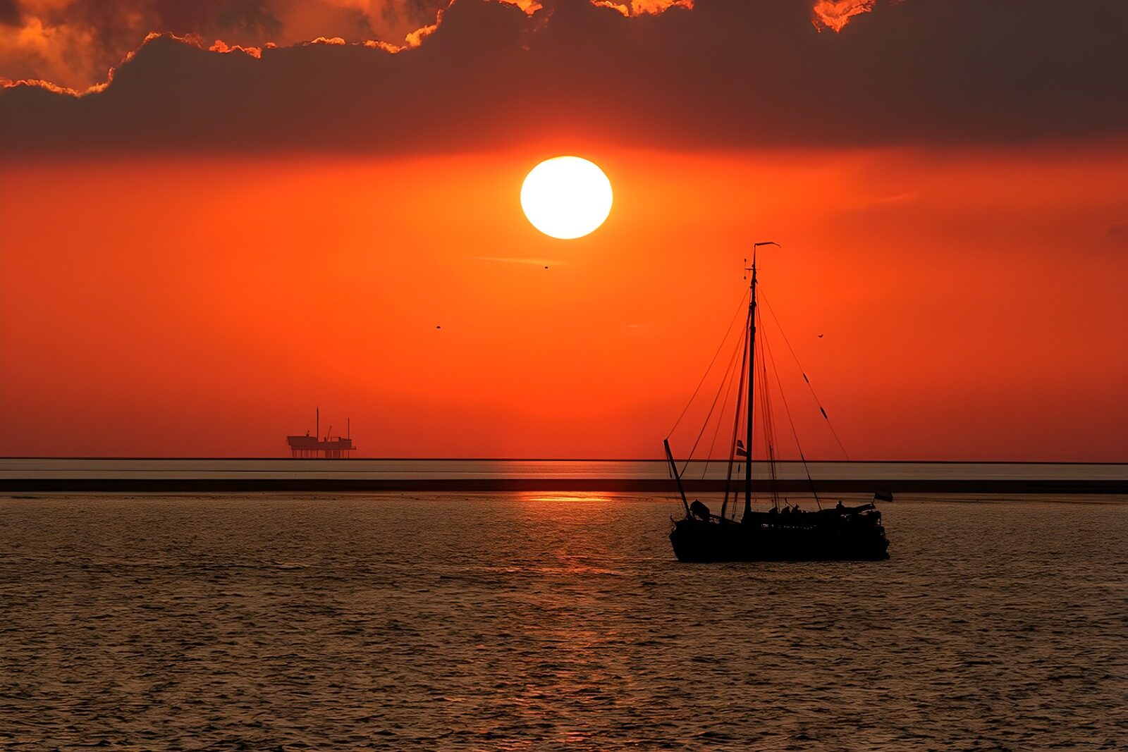 CW6952980: Zonsondergang boven de zee met zeilboot