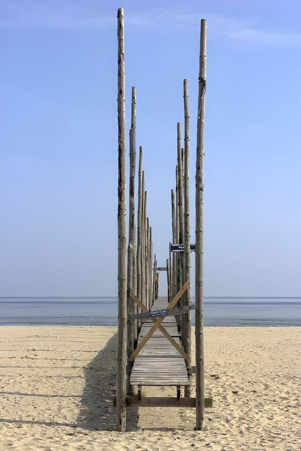 CW7315110: Rustige houten loopbrug naar de zee